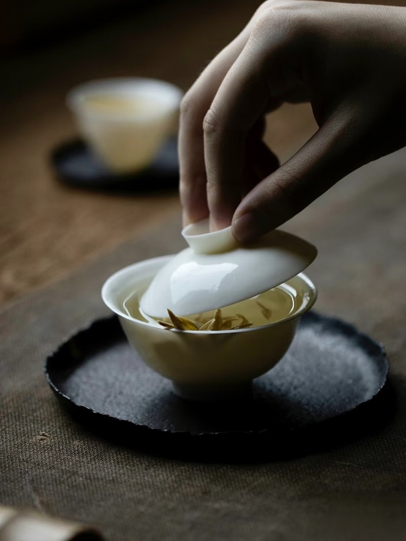Lifting the lid of a gaiwan tea bowl