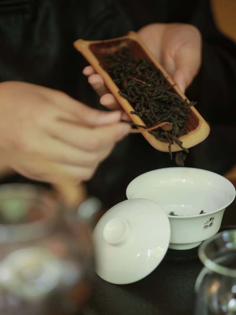 Measuring tea leaves with a bamboo scoop
